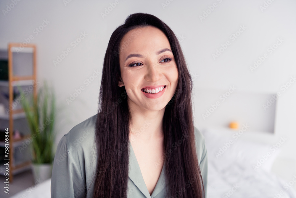Photo portrait of attractive young woman toothy smile look empty space wear trendy gray pajama isolated on white modern interior design Photo portrait of attractive young woman toothy smile look empty space wear trendy gray pajama isolated on white modern interior design