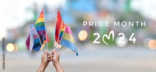 Happy Pride Month 2024 on rainbow flags raising background, concept for celebrations of LGBTQAI people in pride month, June, around the world.