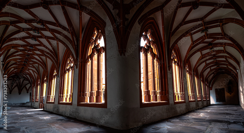 Gothic Architecture Showcased in Sunlit Corridor of Medieval Monastery