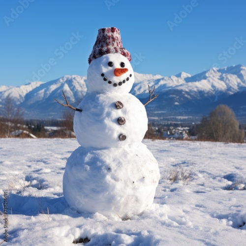 A snowman stands in a snowy field with mountains in the background © Adobe Contributor