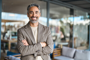 Happy middle aged business man entrepreneur looking at camera outdoors. Smiling confident mature businessman professional executive, successful lawyer wearing suit standing arms crossed, portrait.