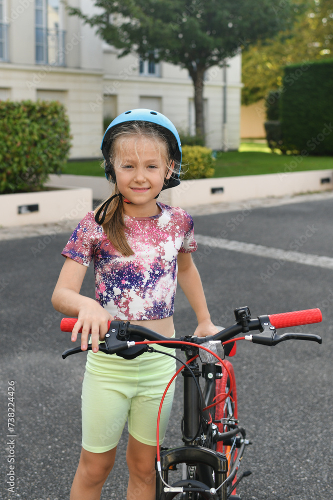 Obraz premium Girl holding her red bike