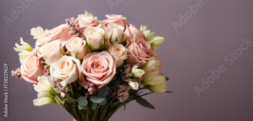 woman in a holding a beautiful blossoming flower bouquet of fresh roses, carnations, matthiola, in pink and pastel cream colors on the grey wall background © Jam