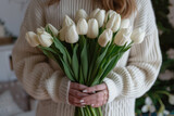 female holding bouquet of white tulips in her hands close up