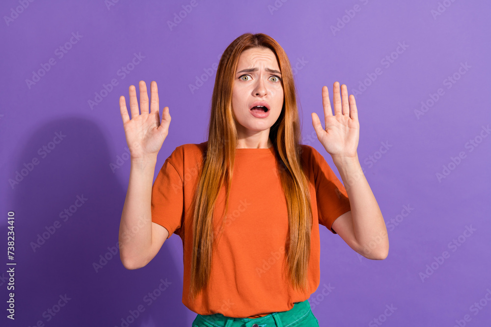 Close up photo of amazed young red hair girl raised arms up when horrified looking at scary monster isolated on purple color background Close up photo of amazed young red hair girl raised arms up when horrified looking at scary monster isolated on purple color background