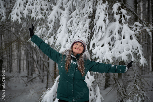 Winter Joy: Woman with Arms Raised in Snowy Forest