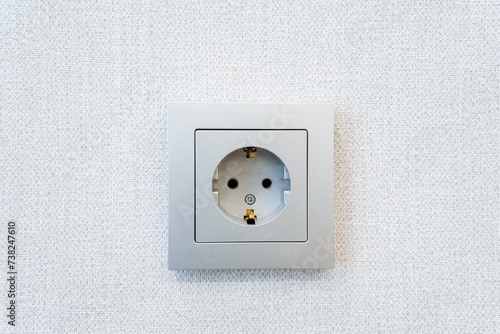 Wall socket on wooden wall, metal with white finish, circular shape