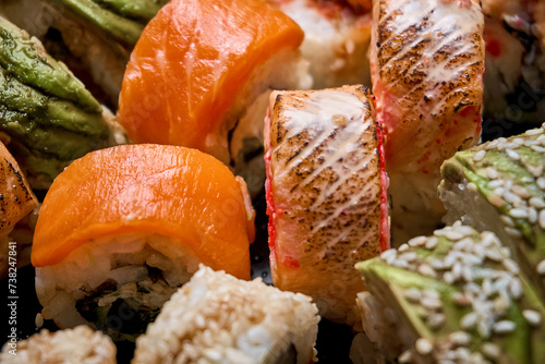 Close-up of a sushi assortment with salmon. Tuna roll, avocado roll, caviar. Sushi delivery, photo for the menu