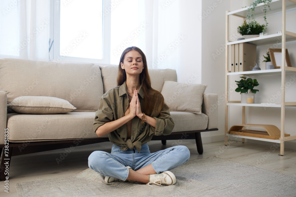 Obraz premium Tranquil Living: Serene Woman Meditating on a Cosy Sofa in Modern Apartment