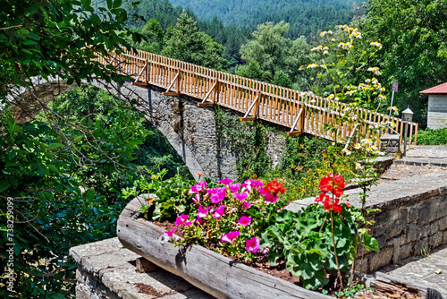 The old stone arched bridge over Aoos river at Vovoussa village, Zagori region, Ioannina, Epirus, Greece.