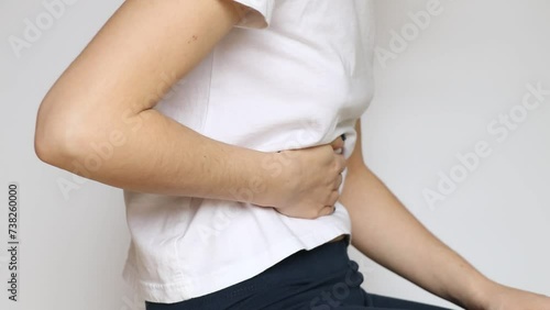 Girl sitting and holding her stomach, acute abdominal pain, abdominal pain photo