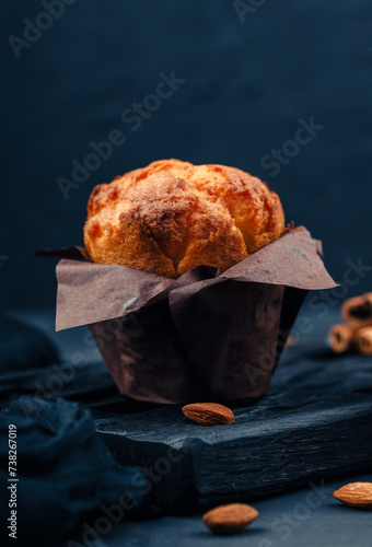  freshly baked golden cupcake with walnuts on a wooden serving board on a brown background. cracked walnuts. top view. a place to copy. The concept of nutrition. sweet homemade cakes. side view