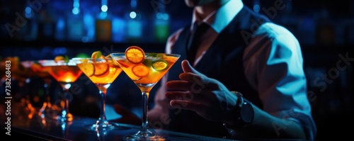 bartender serving orange cocktail with citrus slices. Fresh summer drink in a nightclub. Tasty cocktails on night party in dark room. Alcoholic cocktail row on bar table, colorful party