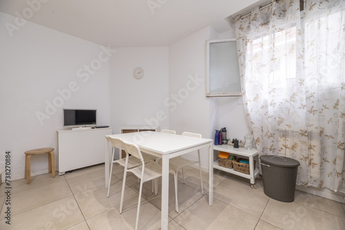 office with white wooden table and plastic chairs of the same color and window with patterned curtains