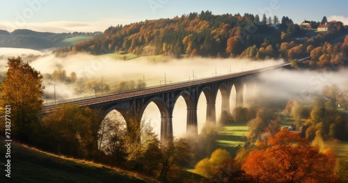 The Enchanting View of a Railway Bridge in Autumn, Amidst a Village's Foggy Dawn