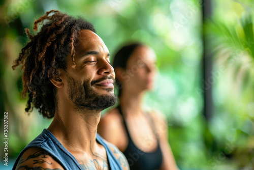 man and a woman enjoying a yoga class, with a serene expression on their faces