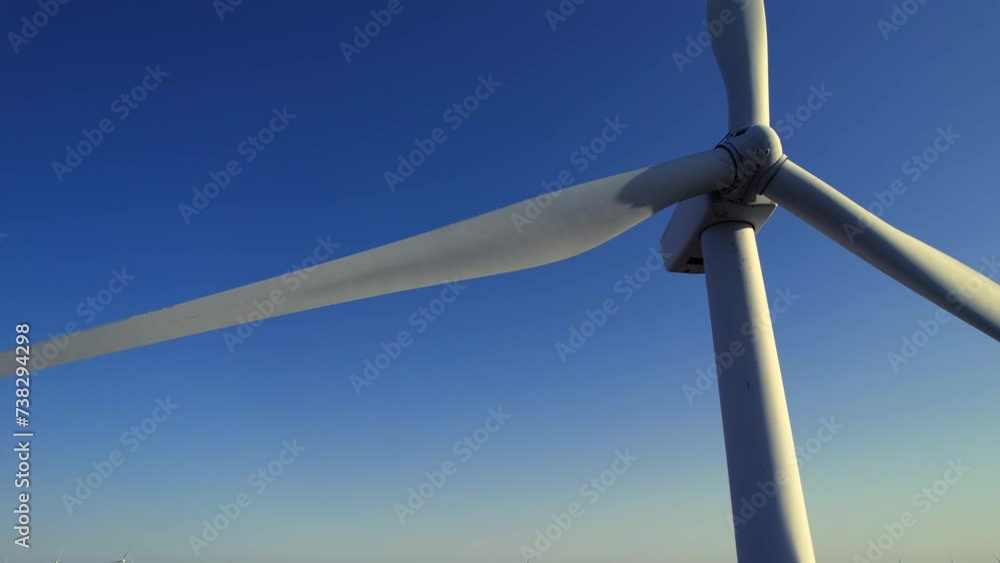 Aerial close up shot of wind mills turbine rotating by the wind and generating renewable green energy. Closeup of a wind turbine during golden hour sunset. Energy alternative and environment ecology. Aerial close up shot of wind mills turbine rotating by the wind and generating renewable green energy. Closeup of a wind turbine during golden hour sunset. Energy alternative and environment ecology.