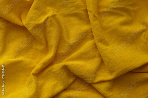 A yellow crumpled fabric texture background. Close up.