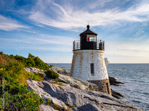Castle Hill Lighthouse in summer overlooking Narragansett Bay, Newport Rhode Island, a beautiful scenic New England landscape. The 1890 light house is built right into the cliff.
