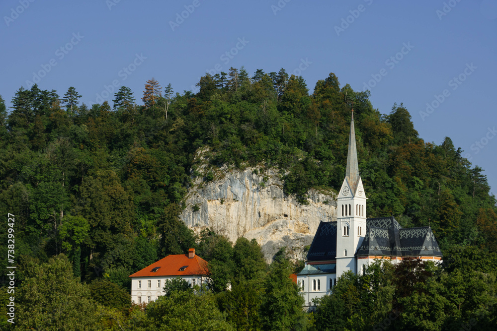 church in the village with tall grey tower and rocky mountain