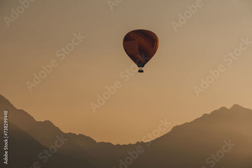hot air orange balloon in flight over beautiful clear morning sky photo
