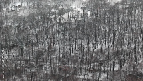 Aerial of leafless trees in snowy Poconos landscape under cloudy sky at sunset in Macungie photo