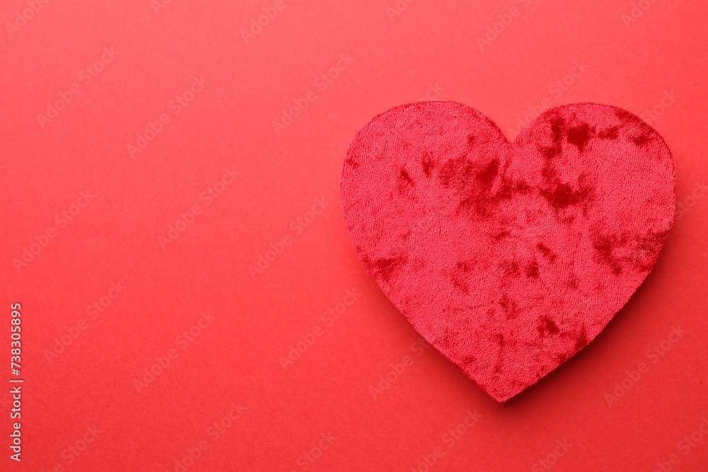 One velvet heart on red background, top view. Space for text