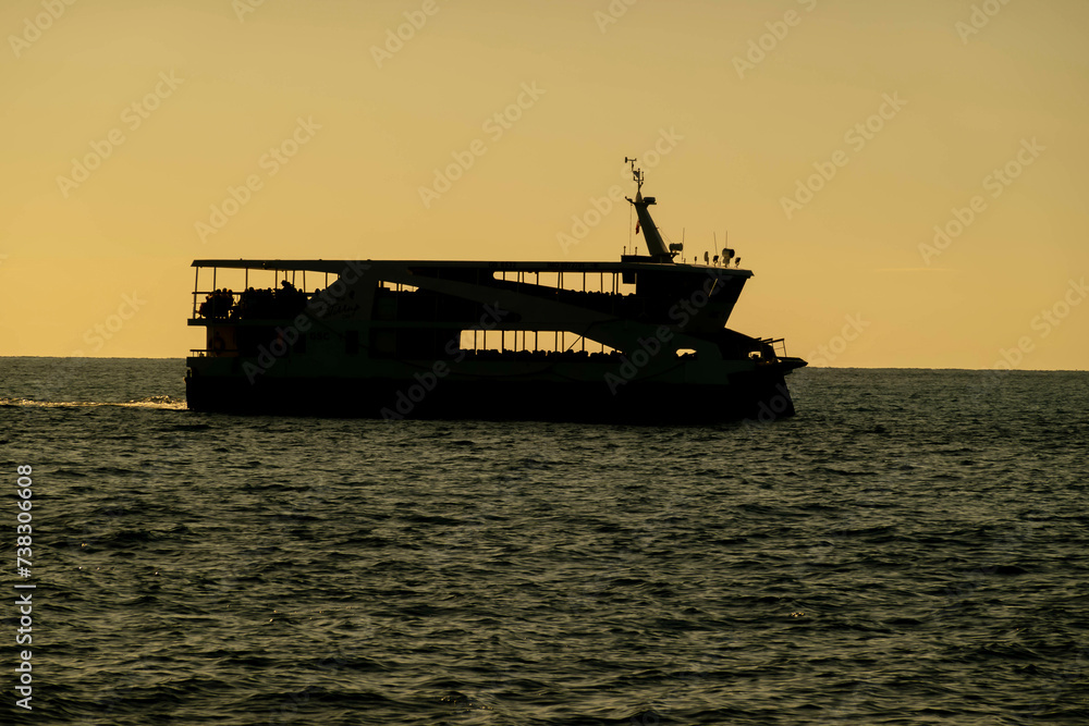 Caribbean Twilight Sail: Graceful Silhouette of a Cruise Ship Gliding on Azure Waters, a Symphony of Elegance Beneath the Setting Sun