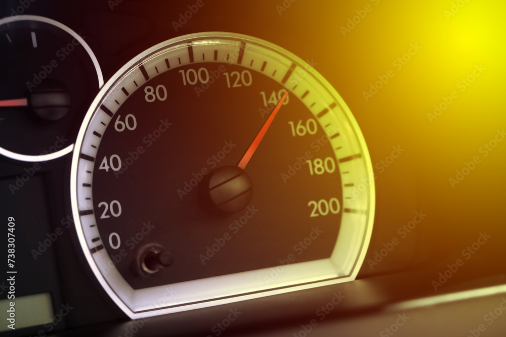 Fototapeta premium Speedometer on car dashboard under yellow light, closeup