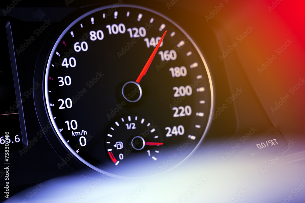 Speedometer on car dashboard under red and orange light, closeup Speedometer on car dashboard under red and orange light, closeup
