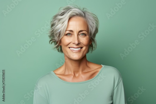 Happy senior woman. Portrait of beautiful mature woman looking at camera and smiling while standing against green background