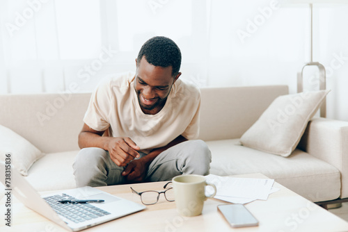 African American Freelancer Working on Laptop in a Modern Home Office, Feeling Tired and Sad © SHOTPRIME STUDIO
