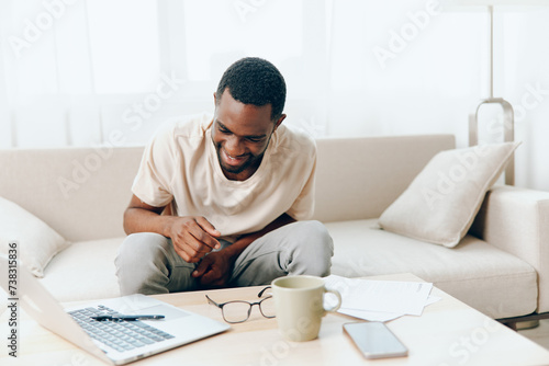 African American Freelancer Working on Laptop in a Modern Home Office, Feeling Tired and Sad