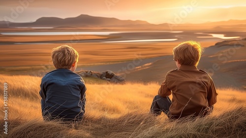 Close-up of the boy s friends sitting against the background of steppes and sunset