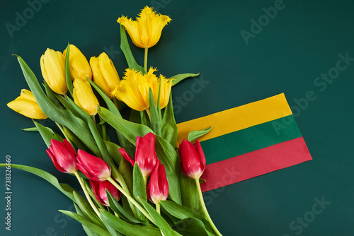 Congratulation for March 11, Lithuania Independence Day. Lithuanian tricolor and bouquets of tulips photo