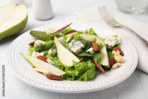 Delicious pear salad on white tiled table, closeup