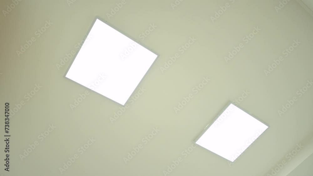 Ceiling with Led panel of a new modern building. Turning on and off light on the ceiling of a room Ceiling with Led panel of a new modern building. Turning on and off light on the ceiling of a room