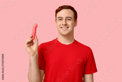 Handsome young man with vibrator on pink background