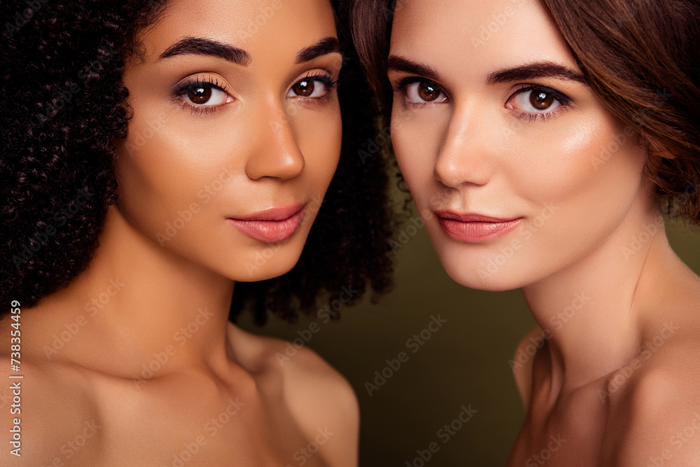 Closeup of two dreamy ladies without clothing holding faces together smiling isolated on khaki color background Closeup of two dreamy ladies without clothing holding faces together smiling isolated on khaki color background