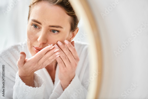 Obraz na plátně beautiful woman in white comfortable bathrobe wearing her contact lenses near mi