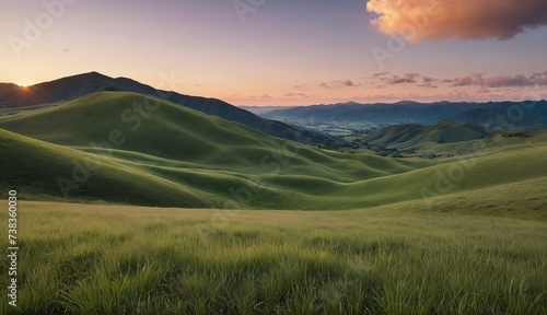 A tranquil sunset over rolling green hills with lush grass in the foreground and distant mountains under a soft sky. Generative AI. © zax