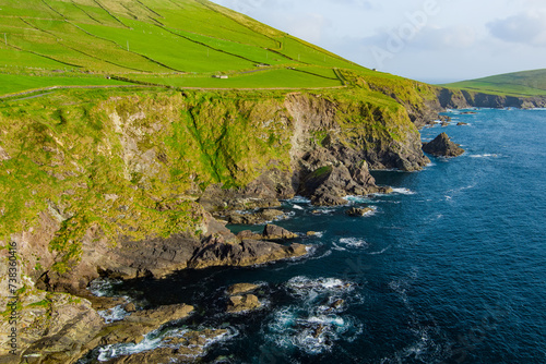 Dunquin or Dun Chaoin pier, Ireland's Sheep Highway. Aerial view of narrow pathway winding down to the pier, ocean coastline, cliffs. Popular location on Slea Head Drive and Wild Atlantic Way. photo