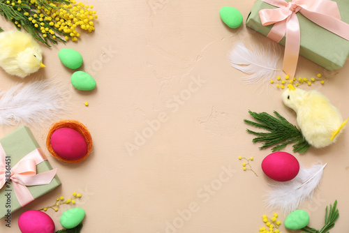 Frame made of Easter eggs, gifts, chickens and mimosa on beige background