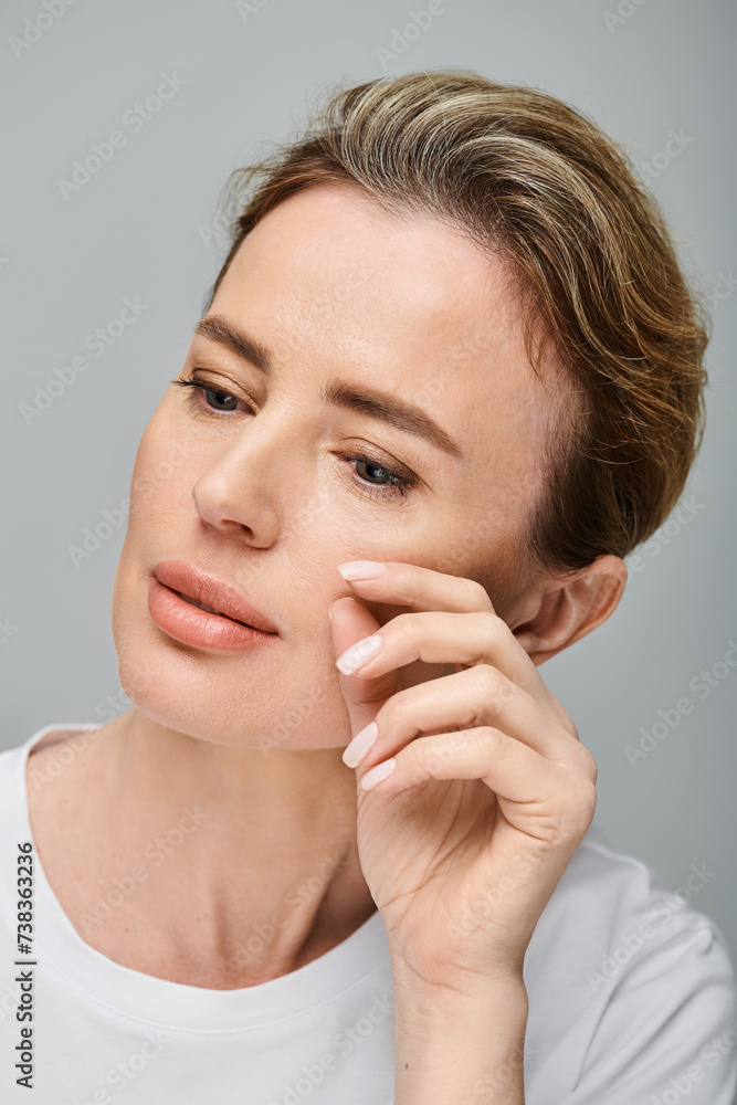 beautiful blonde woman with contact lenses and collected hair looking away on gray backdrop beautiful blonde woman with contact lenses and collected hair looking away on gray backdrop