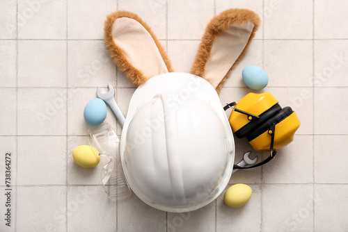 Canvas Print Bunny ears with Easter eggs, hardhat and construction worker tools on white tile