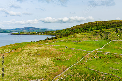 Aerial view of endless lush pastures and farmlands of Ireland. Beautiful Irish countryside with emerald green fields and meadows.