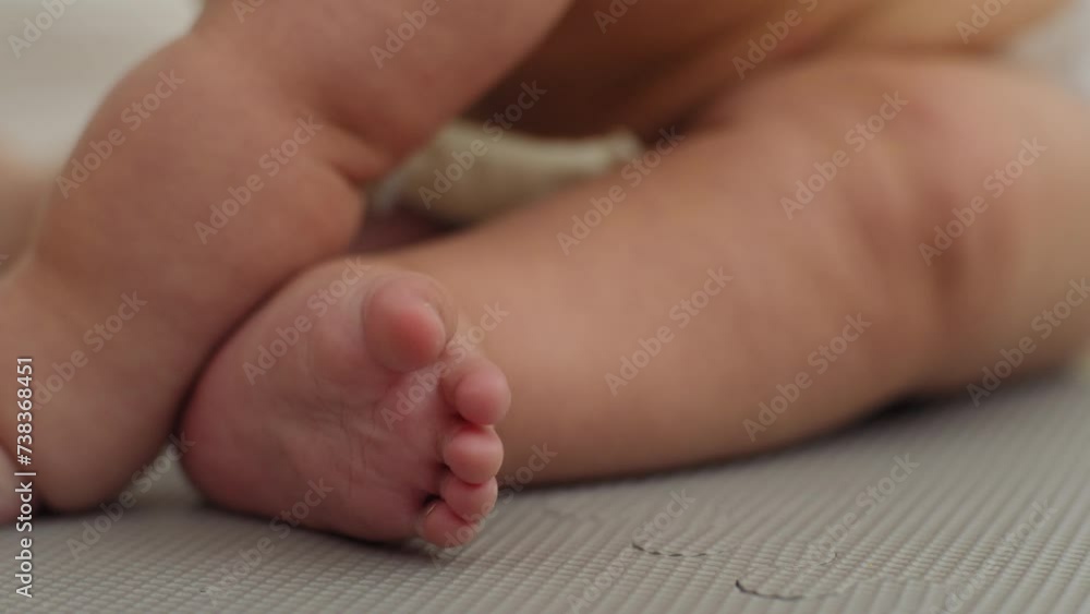Closeup shot of a baby boy's feet while he plays on the floor Closeup shot of a baby boy's feet while he plays on the floor