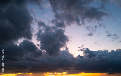 Tropical sunset. Beautiful sunset sky with clouds. Orange sunset, dark clouds in sky. Background of dark clouds before storm. Dramatic clouds. Apocalyptic sky, dark cloud. Overcast cloud.