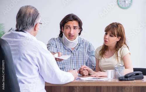 Young couple visiting old male doctor