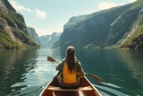 Back view of a young woman paddling a canoe on a serene lake surrounded by majestic fjords Capturing a moment of adventure and tranquility